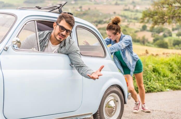 woman pushing car