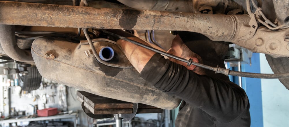 Mechanic removing a fuel tank to deal with water contamination