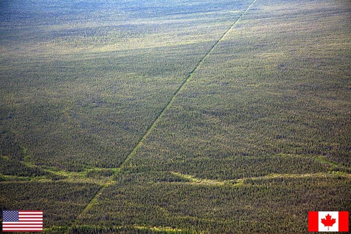 cleared border line through forest between canada and the usa