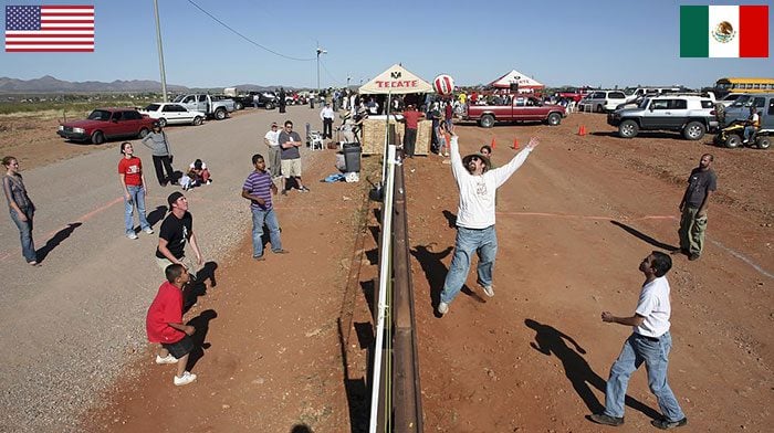 residents of mexico and usa playing volleyball across the border fence at naco